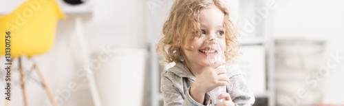 Happy little boy using inhaler