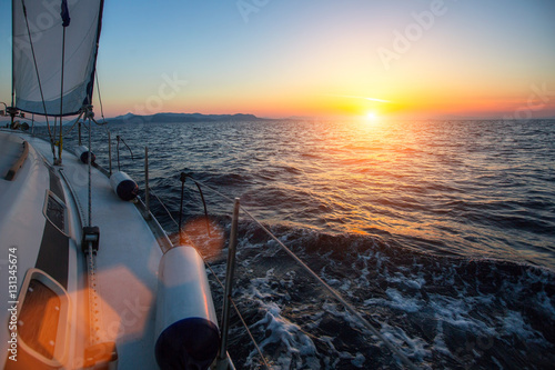 Sailing regatta during sunset in the wind through the waves. Luxury yachts.