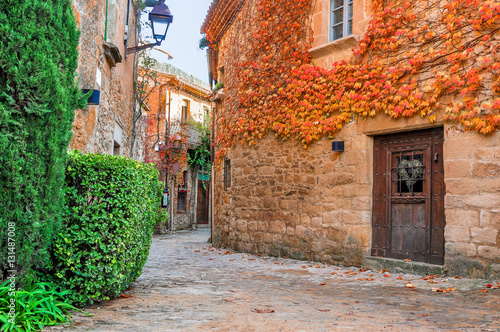 A street in the old town of Peratallada, Catalonia, Spain. Medieval street in the mediaval town in Europe. Panoramic view of old town in beautiful evening light at sunset. 