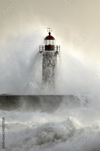 Old lighthouse covered by stormy waves