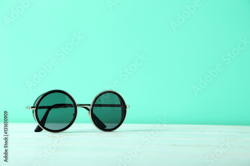 Black sunglasses on a blue wooden table