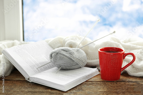 Cup of coffee and knitting on windowsill