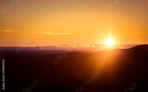 A beautiful landscape with a midnight sun above arctic circle. Dreamy scenery with light flares