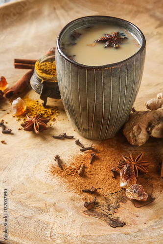 Traditional Indian masala tea in ceramic cup with spices to milk