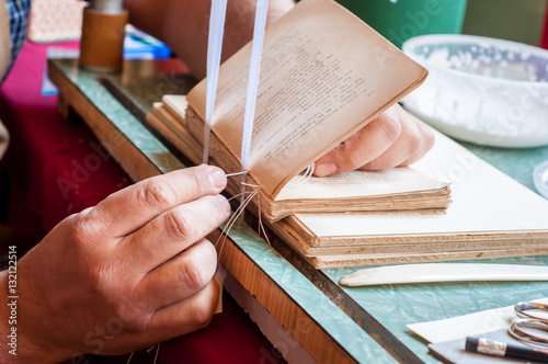 Bookbinding. Male worker binding pages.