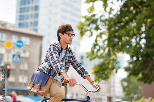 young hipster man with bag riding fixed gear bike