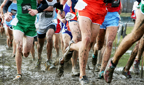 High school boys racing cross country in the mud