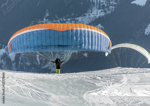 The pilot begins flight on a paraplane with a mountain-skiing slope of Penken - Mayrhofen, Austria
