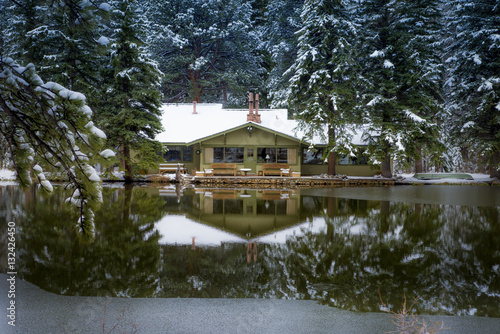 Winter cabin destination travel cold winter forest scene reflected in pond