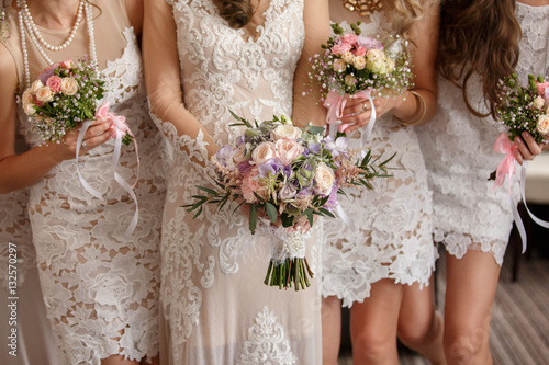 Wedding flowers, bride and bridesmaids holding their bouquets at wedding day. Happy wedding concept