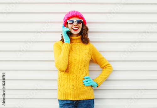 Fashion winter woman talking on smartphone wearing colorful knit