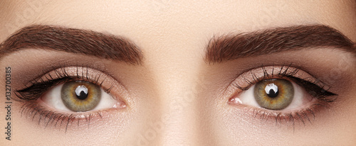 Close-up macro of beautiful female eye with perfect shape eyebrows. Clean skin, fashion naturel make-up. Good vision