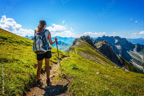 Hiker in boots and backpack holds walking stick