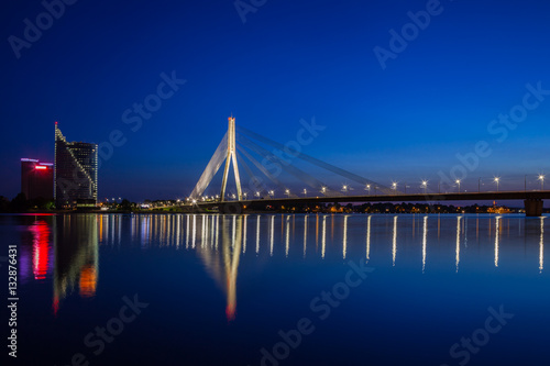 Illuminated bridge at twilight in Riga, Latvia.