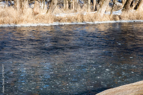 Dark, frozen freshwater of the Apple river in Wisconsin