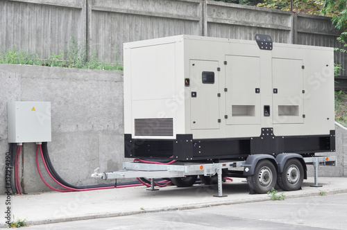 Industrial Diesel Generator. Standby generator. Industrial Diesel Generator for Office Building connected to the Control Panel with Cable Wire. Backup Generator Power.