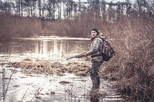 hunter man creeping in swamp during spring hunting season