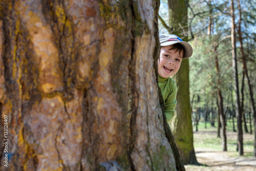 Adorable little boy playing hide and seek