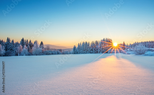 Majestatyczny wschód słońca w krajobrazie gór zimowych.