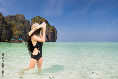Portrait of woman in black swim posing on tropical beach
