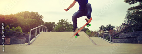 young skateboarder practice ollie trick at skatepark