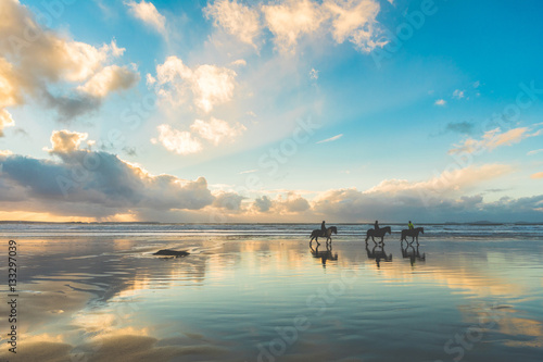 Konie na plaży o zachodzie słońca