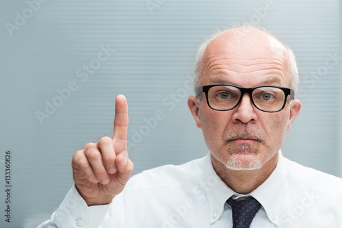 man rising an index finger taking exception