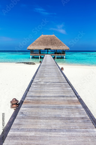 Wooden jetty leading to relaxation lodge. Maldives islands