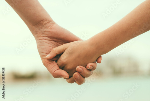 Mother holding hand of her daughter.