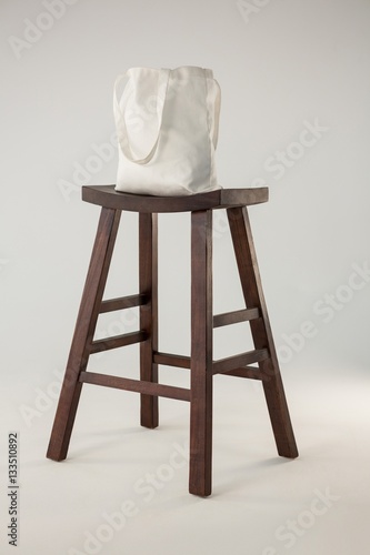 White bag on wooden stool