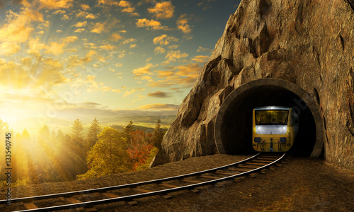 Halna linia kolejowa z pociągiem w tunelu w skale nad krajobraz.