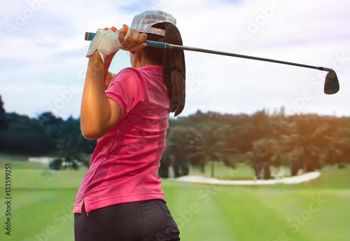 Woman player golf swing on course 