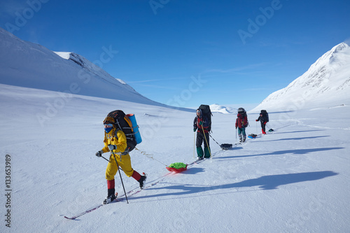 Ski touring group with backpacks and sleds (pulkas)