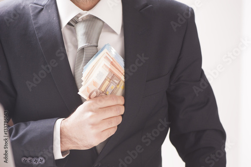 Businessman putting money in his pocket