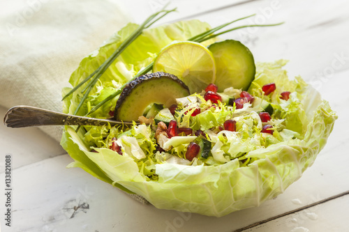 Bowl of green salad of cucumber, escarole and avocado,with pomeg