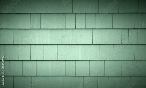 Light green siding on a house or building. Straight parallel lines. Outdoor siding with highlights.. Roofing or construction material.