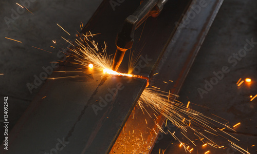 Closeup metal cutter, steel cutting with acetylene torch, industrial worker on manufacturing area.