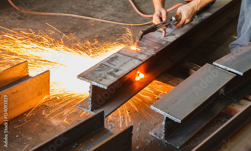 Metal cutter, steel cutting with acetylene torch, industrial worker on manufacturing area.