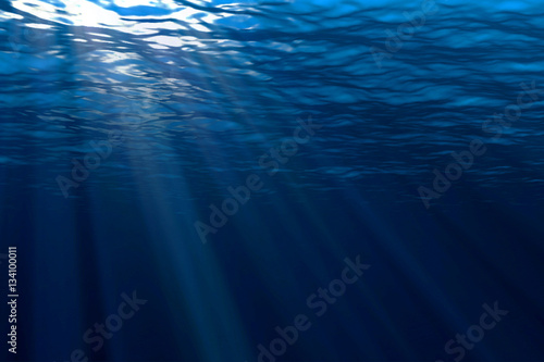 deep blue ocean waves from underwater background, light rays