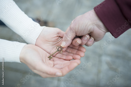 鍵を手渡す親子の手