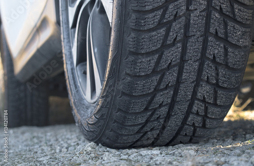 Close up of car's winter tyre tread on the gravel road