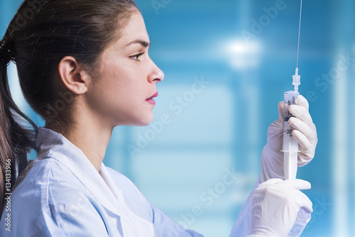 concept of a woman doctor that is preparing an amniocentesis needle for amniotic fuid extraction