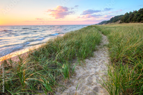 A Walk On The Beach. Sandy trail winds along a Great Lakes beach with a sunset horizon and sand dunes as a backdrop. Muskegon, Michigan.