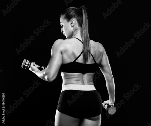 Young woman training with dumbbells. Black and white photo