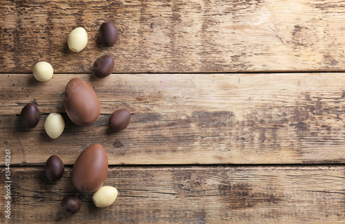 Chocolate Easter eggs and sweets on wooden background