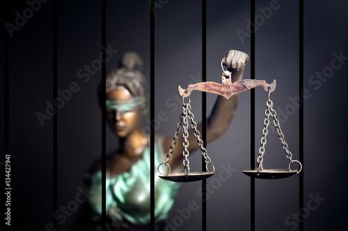 Lady Justice against jail background