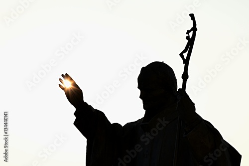 Silhouette of statue of pope John Paul The Second with afternoon sun in his palm, castle Nitra, Slovakia