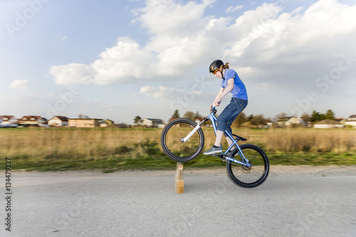 Jugendlicher übt Tricks, Sprünge mit dem Bike auf der Strasse