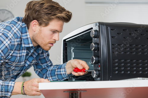 man repairing microwave