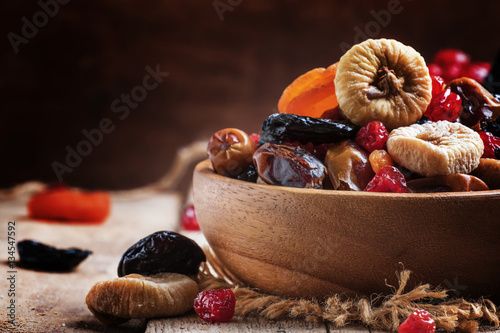 Healthy food: mix from dried fruits in bowl, old wooden backgrou
